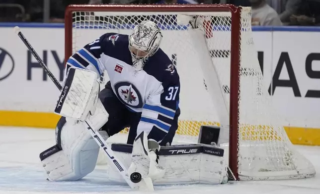 Winnipeg Jets goaltender Connor Hellebuyck stops the puck during the first period of an NHL hockey game against the New York Rangers Tuesday, Nov. 12, 2024, in New York. (AP Photo/Seth Wenig)