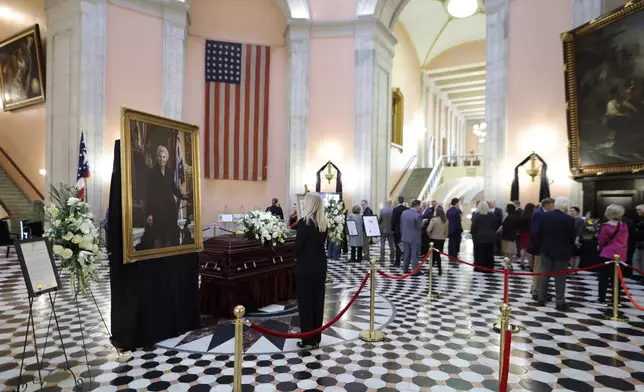 A mourner pauses at the casket for former Ohio speaker of the house Jo Ann Davidson as it lie in state in the rotunda of the Ohio Sate House in Columbus, Ohio, Thursday, Oct. 31, 2024. (AP Photo/Paul Vernon).