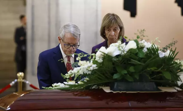 Ohio governor Mike DeWine, left, and his wife Fran pause at the casket for former Ohio House speaker Jo Ann Davidson as it lie in state in the rotunda of the Ohio Statehouse in Columbus, Ohio, Thursday, Oct. 31, 2024. (AP Photo/Paul Vernon)