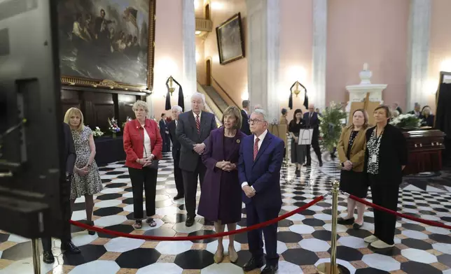 Ohio governor Mike DeWine, right, and his wife Fran watch a slide shoe honoring former Ohio House speaker Jo Ann Davidson as her casket lie in state in the rotunda of the Ohio Statehouse in Columbus, Ohio, Thursday, Oct. 31, 2024. (AP Photo/Paul Vernon)