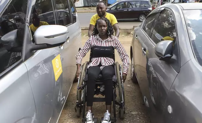 Daniel Gatura, Co-founder of Ace Mobility company, helps Carol Mwikali to get inside Ace Mobility vehicle in Nairobi, Kenya Wednesday, Oct. 9, 2024. (AP Photo/Andrew Kasuku)