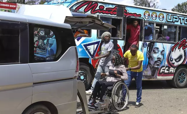 Daniel Gatura, Co-founder of Ace Mobility company, helps Carol Mwikali to get inside an Ace Mobility vehicle in Nairobi, Kenya, Wednesday, Oct. 9, 2024. (AP Photo/Andrew Kasuku)