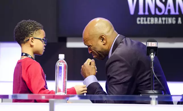 Former Toronto Raptors player Vince Carter is consoled by his son, Vince Carter Jr. while overcome by emotion when speaking to media ahead of his number retirement, before an NBA basketball game between the Toronto Raptors and the Sacramento Kings at the Scotiabank arena, in Toronto on Saturday, Nov. 2, 2024. (Christopher Katsarov/The Canadian Press via AP)