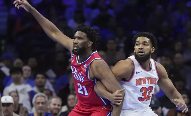 Philadelphia 76ers' Joel Embiid, left, and New York Knicks' Karl-Anthony Towns struggle for position during the first half of an Emirates NBA Cup basketball game, Tuesday, Nov. 12, 2024, in Philadelphia. (AP Photo/Matt Slocum)