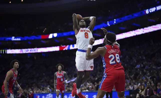 New York Knicks' OG Anunoby (8) goes up for a dunk against Philadelphia 76ers' Guerschon Yabusele (28) during the first half of an Emirates NBA Cup basketball game, Tuesday, Nov. 12, 2024, in Philadelphia. (AP Photo/Matt Slocum)