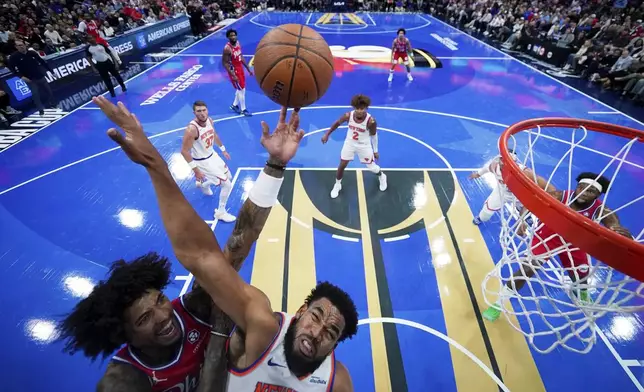 Philadelphia 76ers' Kelly Oubre Jr., left, goes up for a shot against New York Knicks' Karl-Anthony Towns during the first half of an Emirates NBA Cup basketball game, Tuesday, Nov. 12, 2024, in Philadelphia. (AP Photo/Matt Slocum)