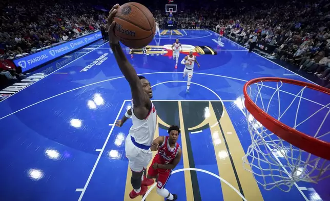 New York Knicks' OG Anunoby, left, goes up for a dunk past Philadelphia 76ers' Kyle Lowry during the second half of an Emirates NBA Cup basketball game, Tuesday, Nov. 12, 2024, in Philadelphia. (AP Photo/Matt Slocum)