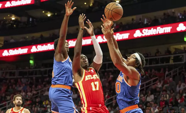 Atlanta Hawks forward Onyeka Okongwu (17) goes up for a rebound against New York Knicks center Jericho Sims, right, and forward OG Anunoby, left, during the first half of an NBA basketball game, Wednesday, Nov. 6, 2024, in Atlanta. (AP Photo/Jason Allen)