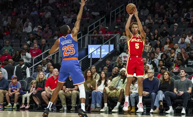 Atlanta Hawks guard Dyson Daniels (5) shoots a three pointer while guarded by New York Knicks forward Mikal Bridges (25) during the first half of an NBA basketball game, Wednesday, Nov. 6, 2024, in Atlanta. (AP Photo/Jason Allen)