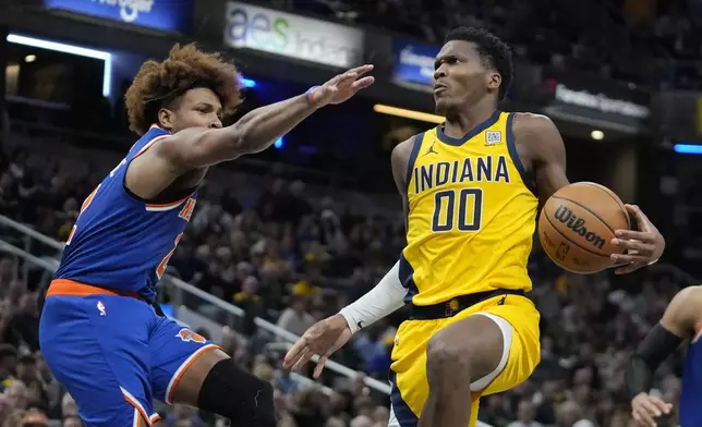 Indiana Pacers' Bennedict Mathurin (00) looks to shoot against New York Knicks' Miles McBride, left, during the second half of an NBA basketball game, Sunday, Nov. 10, 2024, in Indianapolis. (AP Photo/Darron Cummings)