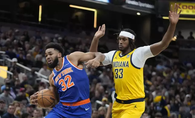 New York Knicks' Karl-Anthony Towns (32) goes to the basket against Indiana Pacers' Myles Turner (33) during the first half of an NBA basketball game, Sunday, Nov. 10, 2024, in Indianapolis. (AP Photo/Darron Cummings)