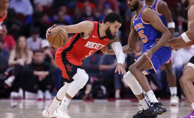 Houston Rockets guard Fred VanVleet (5) attempts to drive around New York Knicks forward Mikal Bridges, right, during the first half of an NBA basketball game Monday, Nov. 4, 2024, in Houston. (AP Photo/Michael Wyke)