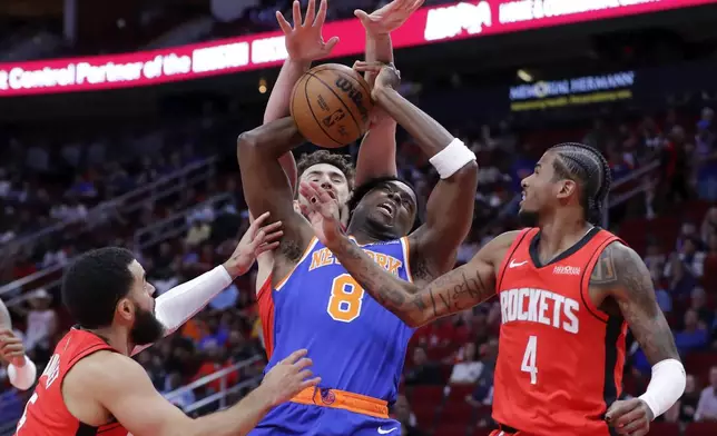 New York Knicks forward OG Anunoby (8) loses the ball as he tries to push a shot up between Houston Rockets guard Fred VanVleet (5), center Alperen Sengun, center back, and guard Jalen Green (4) during the first half of an NBA basketball game Monday, Nov. 4, 2024, in Houston. (AP Photo/Michael Wyke)