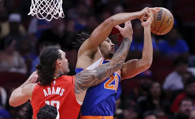 Houston Rockets center Steven Adams, left, knocks away the rebound from New York Knicks center Jericho Sims (20) during the first half of an NBA basketball game Monday, Nov. 4, 2024, in Houston. (AP Photo/Michael Wyke)