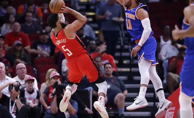 Houston Rockets guard Fred VanVleet (5) puts up a shot as New York Knicks guard Jalen Brunson, right, defends during the first half of an NBA basketball game Monday, Nov. 4, 2024, in Houston. (AP Photo/Michael Wyke)