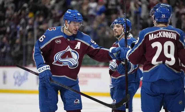 Colorado Avalanche right wing Mikko Rantanen (96) celebrates an empty net goal against the Seattle Kraken with teammate Nathan Nathan MacKinnon (29) during the third period of an NHL hockey game Tuesday, Nov. 5, 2024, in Denver. (AP Photo/Jack Dempsey)