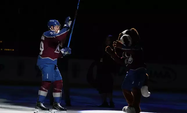 Colorado Avalanche center Nathan MacKinnon waves to the crowd after being announced as the number one star of the game against the Seattle Kraken following an NHL hockey game Tuesday, Nov. 5, 2024, in Denver. (AP Photo/Jack Dempsey)