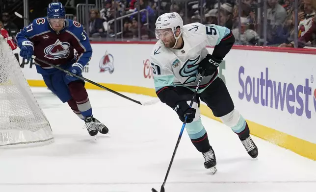 Seattle Kraken center Shane Wright (51) moves the puck against Colorado Avalanche center Casey Mittelstadt (37) during the second period of an NHL hockey game Tuesday, Nov. 5, 2024, in Denver. (AP Photo/Jack Dempsey)