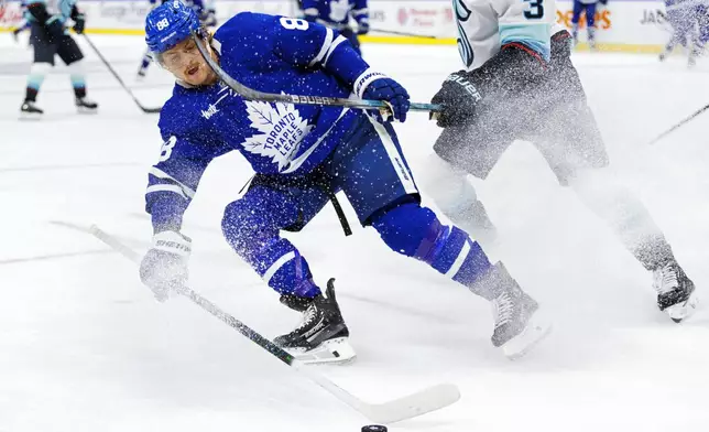 Toronto Maple Leafs' William Nylander (88) battles for the puck during the second period of an NHL hockey game against the Seattle Kraken in Toronto, Thursday, Oct, 31, 2024. (Cole Burston/The Canadian Press via AP)