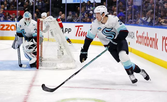 Seattle Kraken's Will Borgen (3) clears the puck around the net during the second period of an NHL hockey game against the Seattle Kraken in Toronto, Thursday, Oct, 31, 2024. (Cole Burston/The Canadian Press via AP)