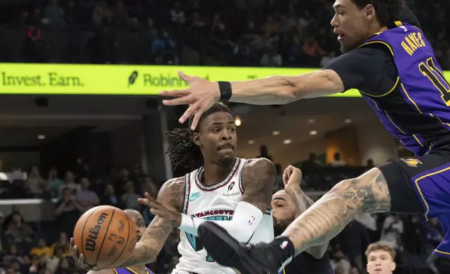 Memphis Grizzlies guard Ja Morant (12) looks to pass defended by Los Angeles Lakers center Jaxson Hayes (11) in the first half of an NBA basketball game Wednesday, Nov. 6, 2024, in Memphis, Tenn. (AP Photo/Nikki Boertman)