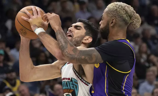 Memphis Grizzlies forward Santi Aldama (7), of Spain, shoots defended by Los Angeles Lakers guard D'Angelo Russell (1) in the first half of an NBA basketball game Wednesday, Nov. 6, 2024, in Memphis, Tenn. (AP Photo/Nikki Boertman)