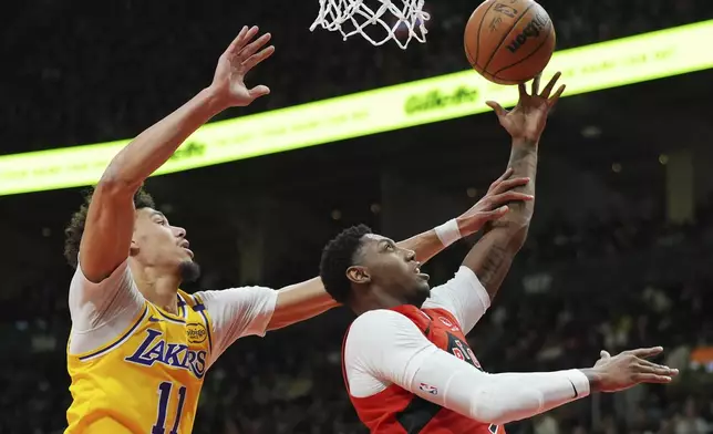 Toronto Raptors' RJ Barrett, right, scores as Los Angeles Lakers' Jaxson Hayes (11) defends during the first half of an NBA basketball game in Toronto on Friday, Nov. 1, 2024. (Frank Gunn/The Canadian Press via AP)