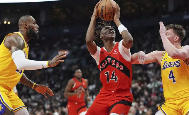 Toronto Raptors' Ja'Kobe Walter (14) shoots between Los Angeles Lakers' LeBron James, left, and Dalton Knecht (4) during the first half of an NBA basketball game in Toronto on Friday, Nov. 1, 2024. (Frank Gunn/The Canadian Press via AP)