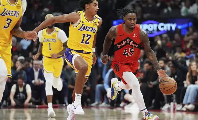 Toronto Raptors' Davion Mitchell (45) drives as Los Angeles Lakers' Max Christie (12) defends during first half of an NBA basketball game in Toronto on Friday, Nov. 1, 2024. (Frank Gunn/The Canadian Press via AP)