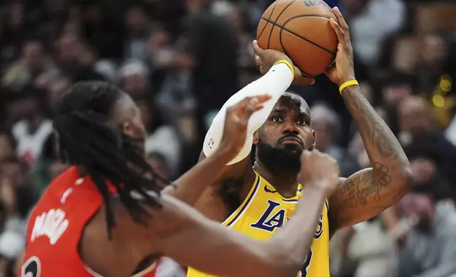 Los Angeles Lakers' LeBron James (23) shoots as Toronto Raptors' Jonathan Mogbo (2) defends during second half of an NBA basketball game in Toronto on Friday, Nov. 1, 2024. (Frank Gunn/The Canadian Press via AP)