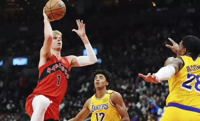 Toronto Raptors' Gradey Dick (1) shoots as Los Angeles Lakers' Max Christie (12) and Rui Hachimura (28) defend during the first half of an NBA basketball game in Toronto on Friday, Nov. 1, 2024. (Frank Gunn/The Canadian Press via AP)