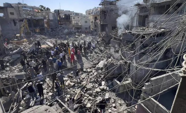 Rescue workers gather at the site of Israeli airstrikes that destroyed buildings facing the city's main government hospital in a densely-populated neighborhood, in southern Beirut, Lebanon, Tuesday, Oct. 22, 2024. (AP Photo/Hussein Malla)