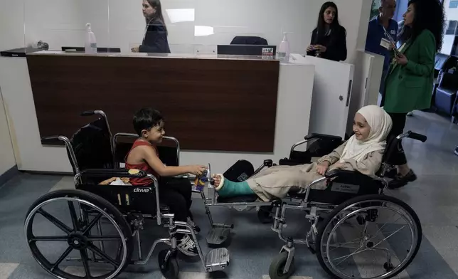 Hussein Mikdad, 4, left, and his cousin Zahraa, right, who were injured on Oct. 2 in an Israeli airstrike at a densely-populated neighborhood south of Beirut, sit on their wheelchairs as they wait to be seen by their doctor at American University of Beirut Medical Center (AUBMC), in Beirut, Lebanon, Tuesday, Nov. 5, 2024. (AP Photo/Bilal Hussein)