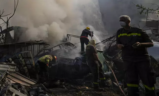 Civil defense workers extinguish a fire as smoke rises from the site of an Israeli airstrike in Dahiyeh, Beirut, Lebanon, Friday, Nov. 1, 2024. (AP Photo/Hassan Ammar)