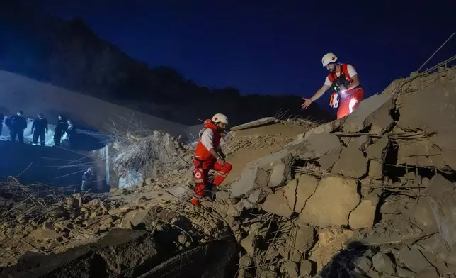 Lebanese Red Cross volunteers and other rescuers search for victims at a house that was hit in an Israeli airstrike in Baalchmay village east of Beirut, Lebanon, Tuesday, Nov. 12, 2024. (AP Photo/Hassan Ammar)