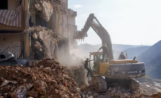 Rescue workers use excavators to remove the rubble of a destroyed building that was hit Tuesday night in an Israeli airstrike, as they search for victims in Barja, Lebanon, Wednesday, Nov. 6, 2024. (AP Photo/Hassan Ammar)