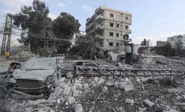 Resident check the site of an Israeli airstrike in Tyre, southern Lebanon, Saturday, Nov. 9, 2024. (AP Photo/Mohammad Zaatari)