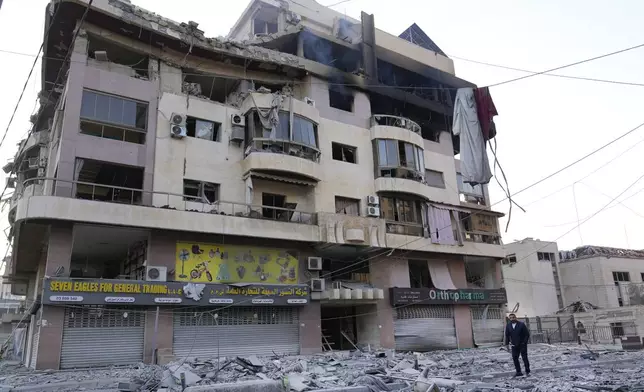 A man passes a destroyed building hit by an Israeli airstrike on Dahiyeh, in the southern suburb of Beirut, Lebanon, Friday, Nov. 1, 2024. (AP Photo/Hussein Malla)