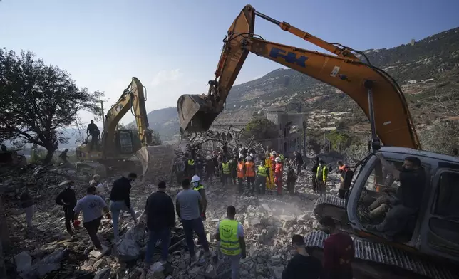 Rescue workers use excavators to remove the rubble of a destroyed house hit in an Israeli airstrike, as they search for victims in Aalmat village, northern Lebanon, Sunday, Nov. 10, 2024. (AP Photo/Hassan Ammar)