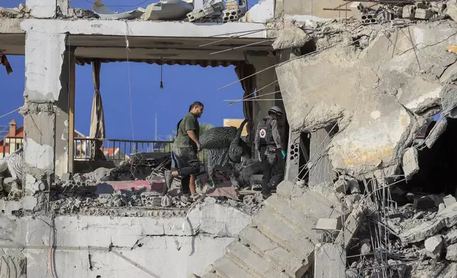 Rescue workers search for victims at a destroyed building hit in an Israeli airstrike, in Ghaziyeh town, south Lebanon, Sunday, Nov. 3, 2024. (AP Photo/Mohammed Zaatari)