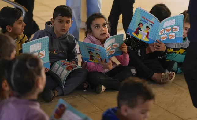 Displaced children, who fled Baalbek city and the nearby towns of Douris and Ain Bourday with their families amid the ongoing Hezbollah-Israel war, study inside at a school being used as a shelter, in Deir Al-Ahmar, east Lebanon, Thursday, Oct. 31, 2024. (AP Photo/Hassan Ammar)