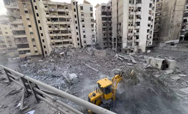 A municipality worker uses a bulldozer to remove the rubble of a destroyed building that was hit in an Israeli airstrike on Dahiyeh, in the southern suburb of Beirut, Lebanon, Friday, Nov. 1, 2024. (AP Photo/Hussein Malla)