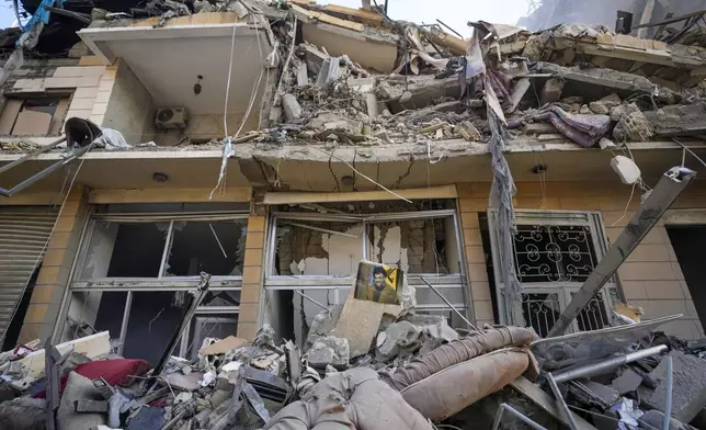 A picture of slain Hezbollah leader Hassan Nasrallah hangs in a destroyed building at the site of an Israeli airstrike in Dahiyeh, Beirut, Lebanon, Saturday, Nov. 9, 2024. (AP Photo/Hassan Ammar)