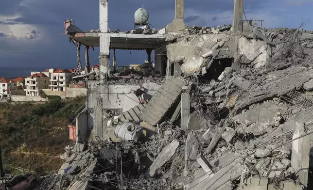 A man inspects a destroyed building hit in an Israeli airstrike, in Ghaziyeh town, south Lebanon, Sunday, Nov. 3, 2024. (AP Photo/Mohammed Zaatari)