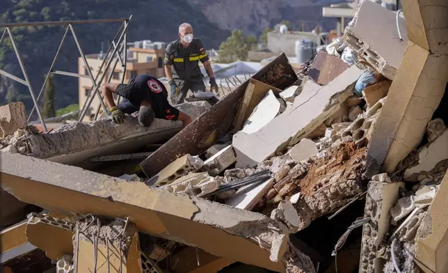 Rescue workers search for victims in the rubble of a destroyed building hit in an Israeli airstrike on Tuesday night, in Barja, Lebanon, Wednesday, Nov. 6, 2024. (AP Photo/Hassan Ammar)