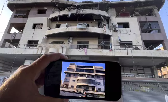 A man shows his newly duplex apartment on his mobile phone how it was before it was attacked by an Israeli airstrike on Dahiyeh, in the southern suburb of Beirut, Lebanon, Friday, Nov. 1, 2024. (AP Photo/Hussein Malla)