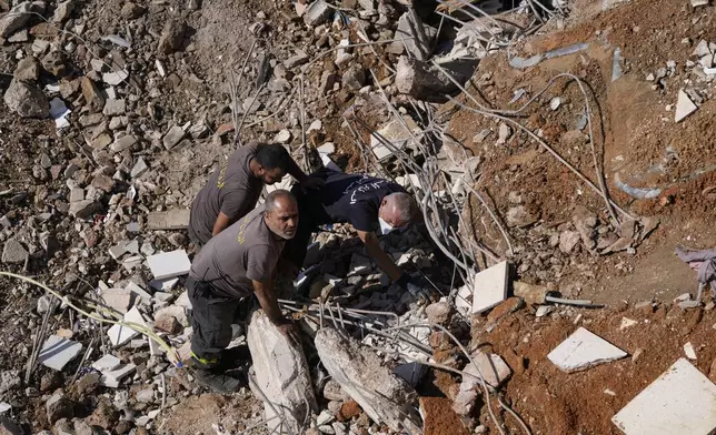 Civil defense workers search for victims in the rubble of a destroyed building hit in an Israeli airstrike on Tuesday night, in Barja, Lebanon, Wednesday, Nov. 6, 2024. (AP Photo/Hassan Ammar)