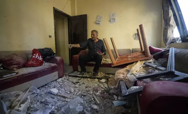 An injured resident sits in his damaged house after an Israeli airstrike hit a building on Tuesday night, in Barja, Lebanon, Wednesday, Nov. 6, 2024. (AP Photo/Hassan Ammar)