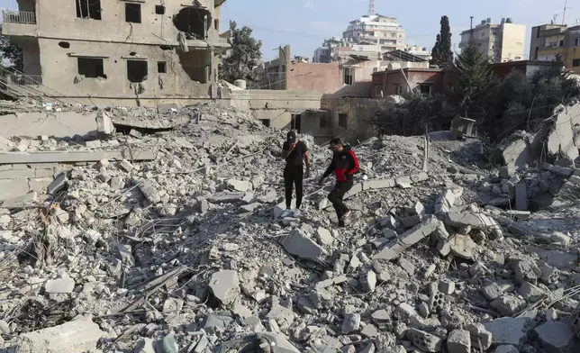 Resident check the site of an Israeli airstrike in Tyre, southern Lebanon, Saturday, Nov. 9, 2024. (AP Photo/Mohammad Zaatari)