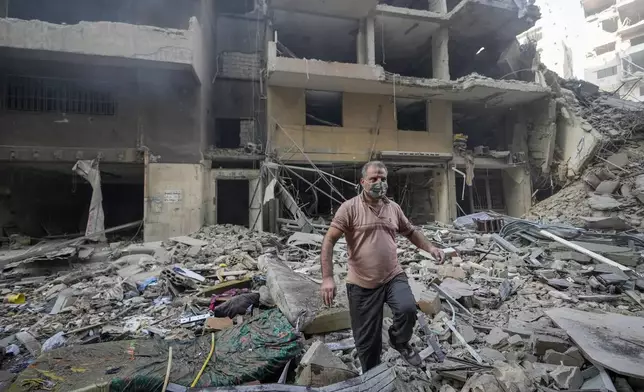 A resident checks the site of an Israeli airstrike in Dahiyeh, Beirut, Lebanon , Saturday, Nov. 9, 2024. (AP Photo/Hassan Ammar)